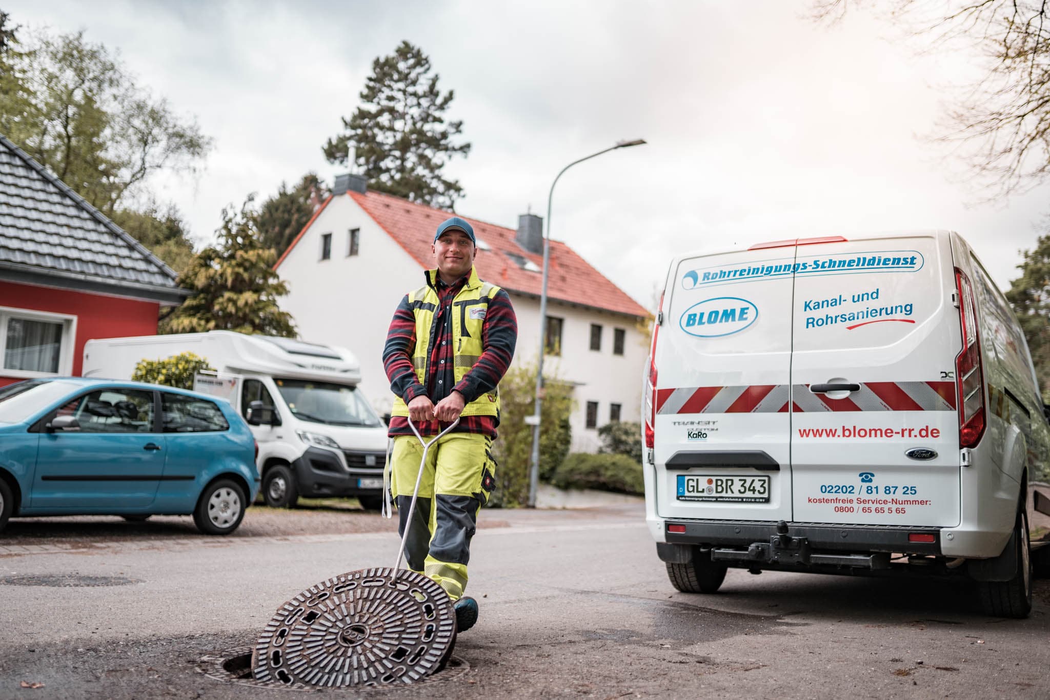 Monteur der Blome Rohrreinigung am geöffneten Kanalschacht