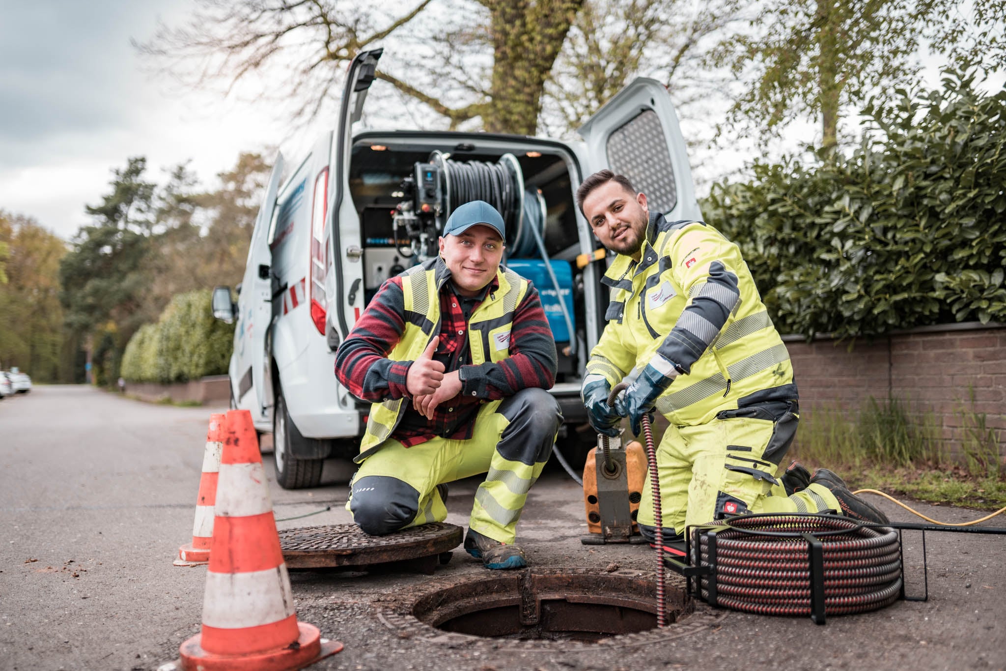 Monteure von Blome Rohrreinigung am geöffneten Kanalschacht