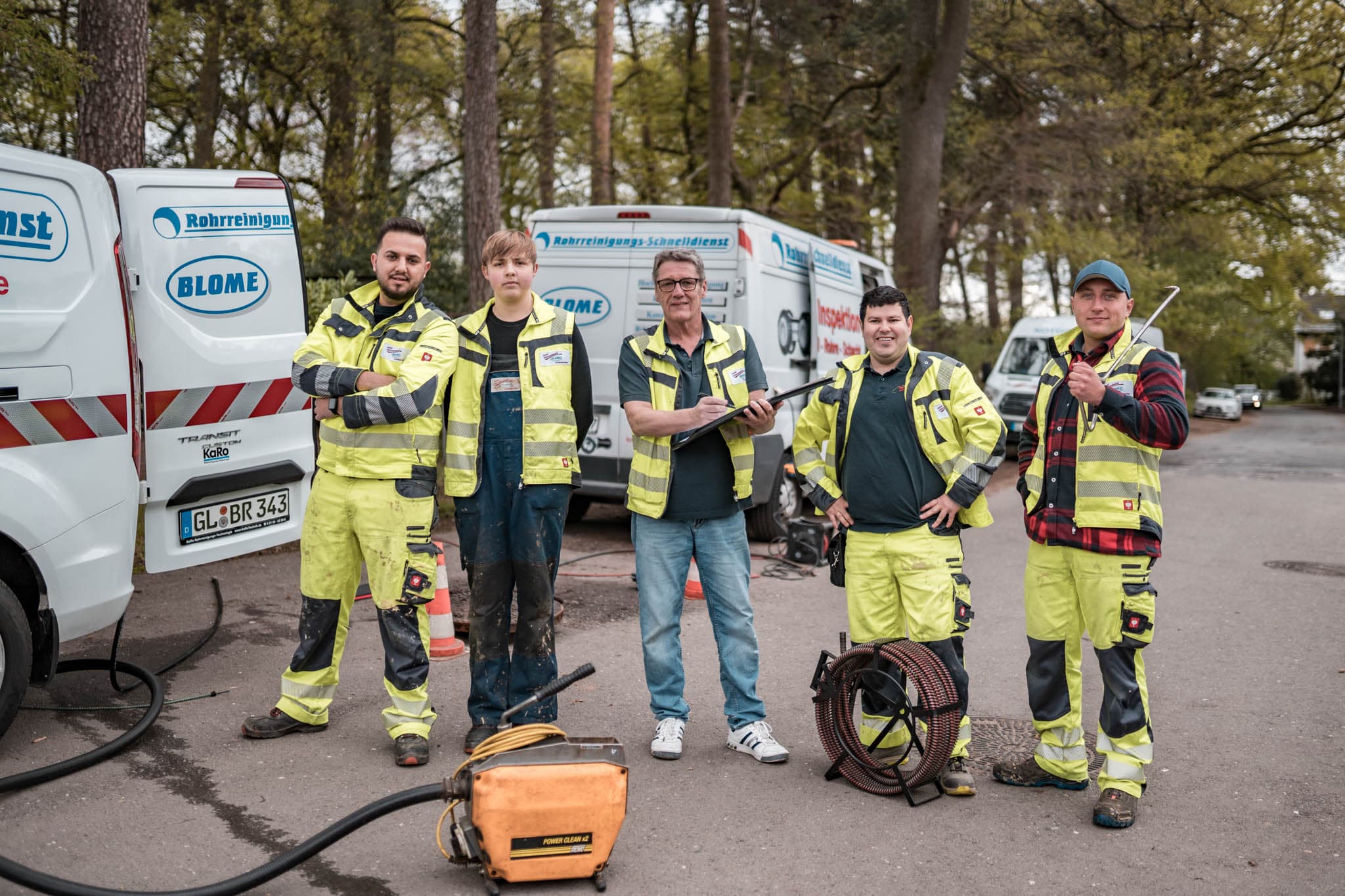 Team von Blome Rohrreinigung vor den Einsatzfahrzeugen in Bergisch Gladbach